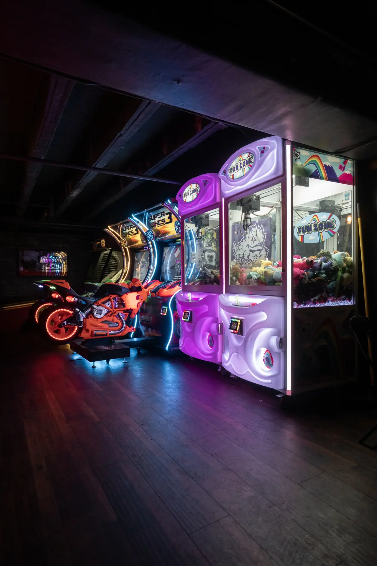 Two claw machines and two racing machines in a line