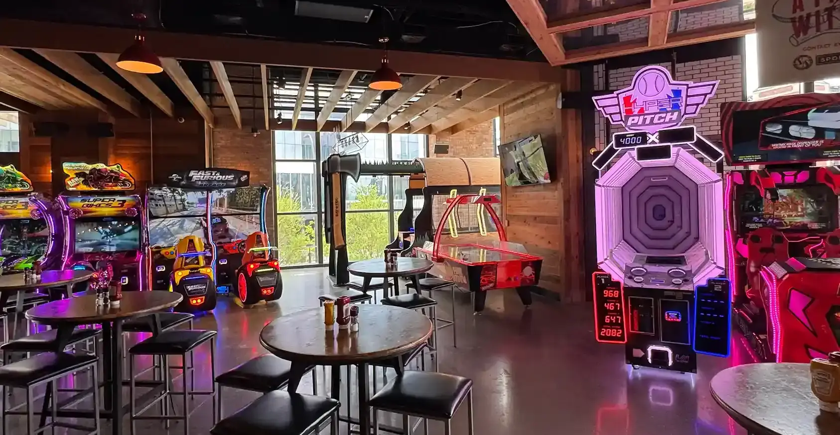 Bar with several arcade games and high top tables