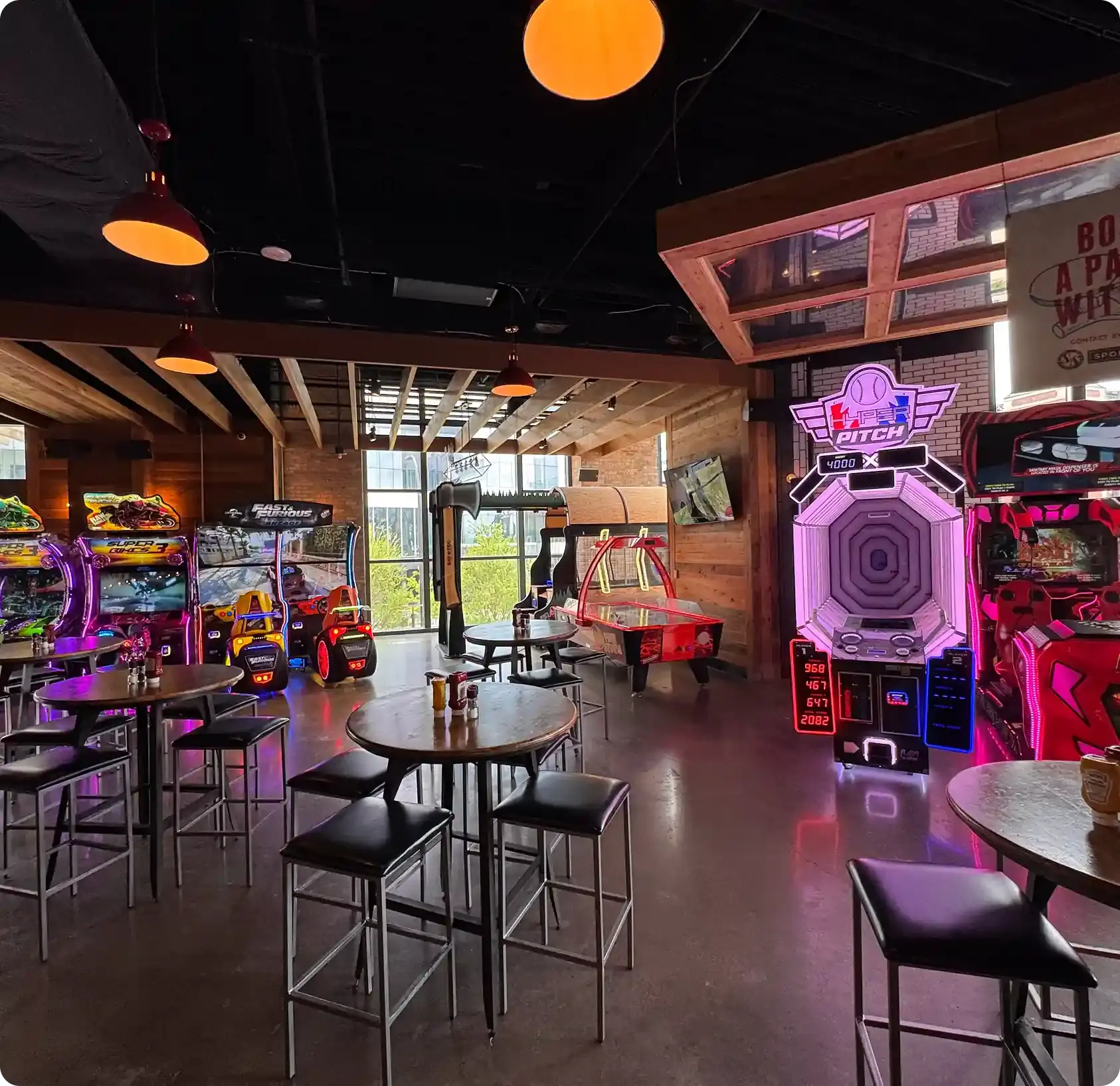 Bar with several arcade games and high top tables